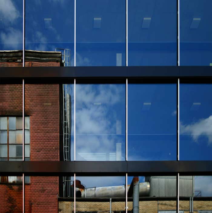 Altes Industriegebäude spiegelt sich in moderner Fensterfront