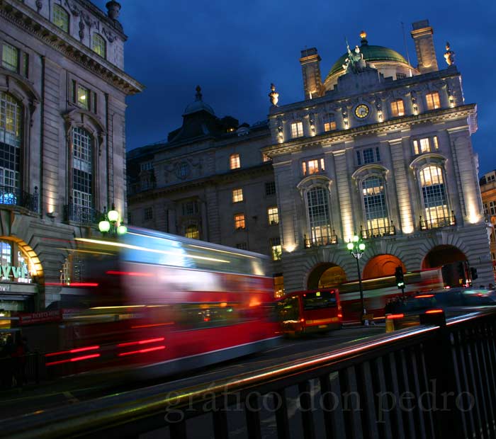 Nachtaufnahme von fahrendem Bus vor historischem Gebäude